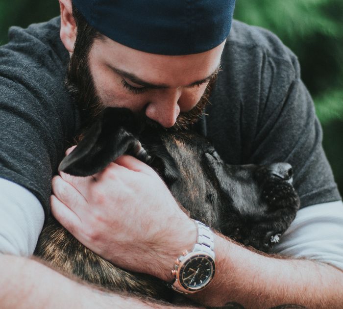 man hugging and kissing a dog